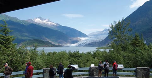 A group of tourists admire the beautiful Alaskan mountain landscape.