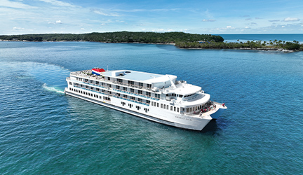 The American Eagle cruise ship sailing through a bright blue waterway.