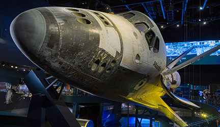 A close up view of Space Shuttle Atlantis, a large, silver space shuttle, on display at the Kennedy Space Center in Cape Canaveral