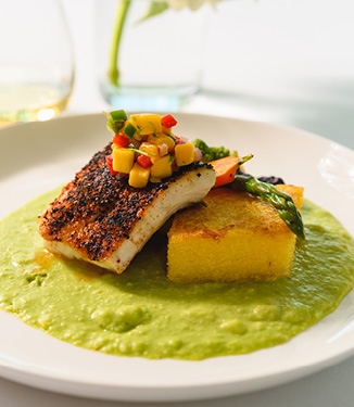 Blackened Florida Grouper, with Caramelized Polenta Cake, Cilantro Lime Grits, and topped with Mango Pico de Gallo and Champagne Butter Sauce served on American Cruise Lines.