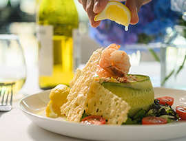 Our signature poached seafood salad appetizer, served on American Cruise Lines embarkation day lunch. A lemon is being squeezed on top of the dish.