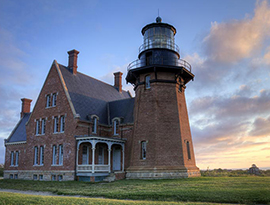 Block Island Southeast Light, a brick lighthouse connected to a brick building in the middle of a grassy field in Block Island.