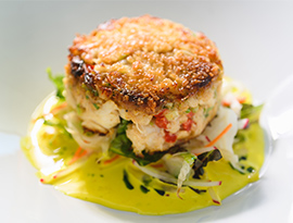 A white plate with Crab Cake served on American Cruise Lines.