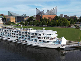 The American Riverboat American Serenade docked along the Tennessee River with views of Chattanooga's Tennessee Aquarium in the background. 