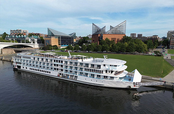 The American Riverboat American Serenade docked along the Tennessee River with views of Chattanooga's Tennessee Aquarium in the background. 