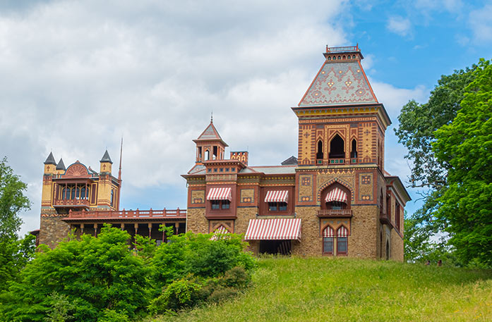 Olana State Historic Site, a historic house museum in Catskill with distinct yellow, blue, and red patterns alongside the building, and red and white striped window awnings.