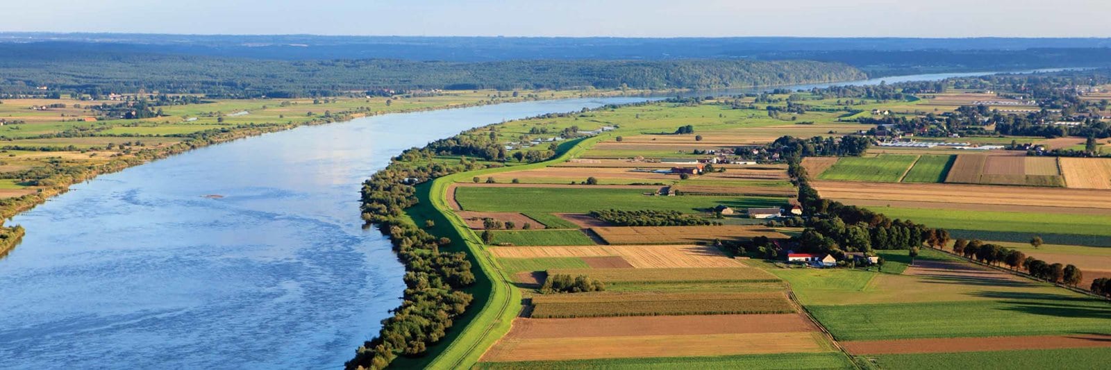 A birds-eye-view of the Mississippi River with vast open land on each side of the wide river. 