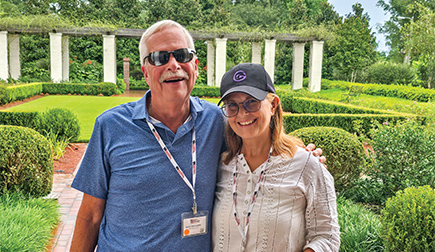 A man and woman smiling together for a photo in front of Houmas House.